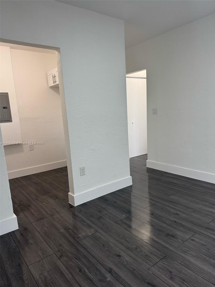 212 Northwest 15th Street, Unit 2 Miami, FL 33136 - Photo 9 of 19 an empty room with wooden floor and white wall