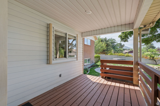 2370 Quail Run Circle East Sandy, UT 84093 - Photo 39 of 54 Covered porch featuring wood-finish decking, horizontal wood railings, and a white paneled ceiling