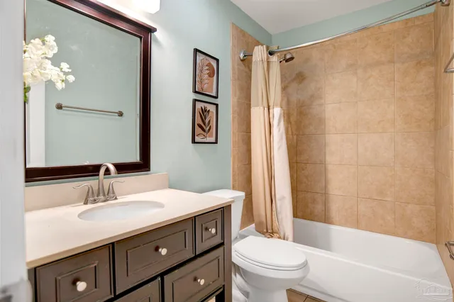 a bathroom with a sink a toilet a mirror a vanity and shower
