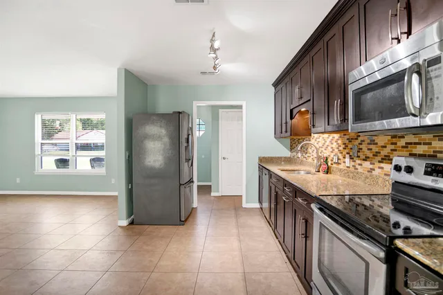 a kitchen with stainless steel appliances granite countertop a stove a refrigerator and a sink