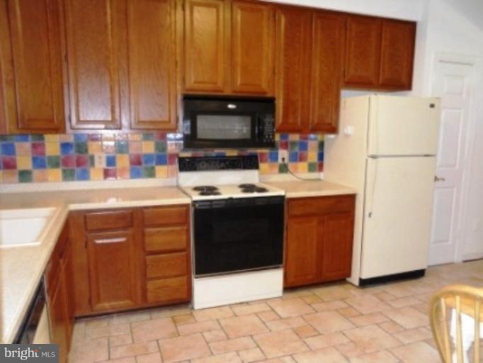 11205 Watermill Lane Silver Spring, MD 20902 - Photo 4 of 12 a kitchen with a cabinets and white appliances