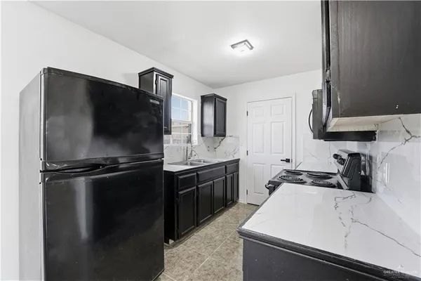 a kitchen with a sink appliances and cabinets