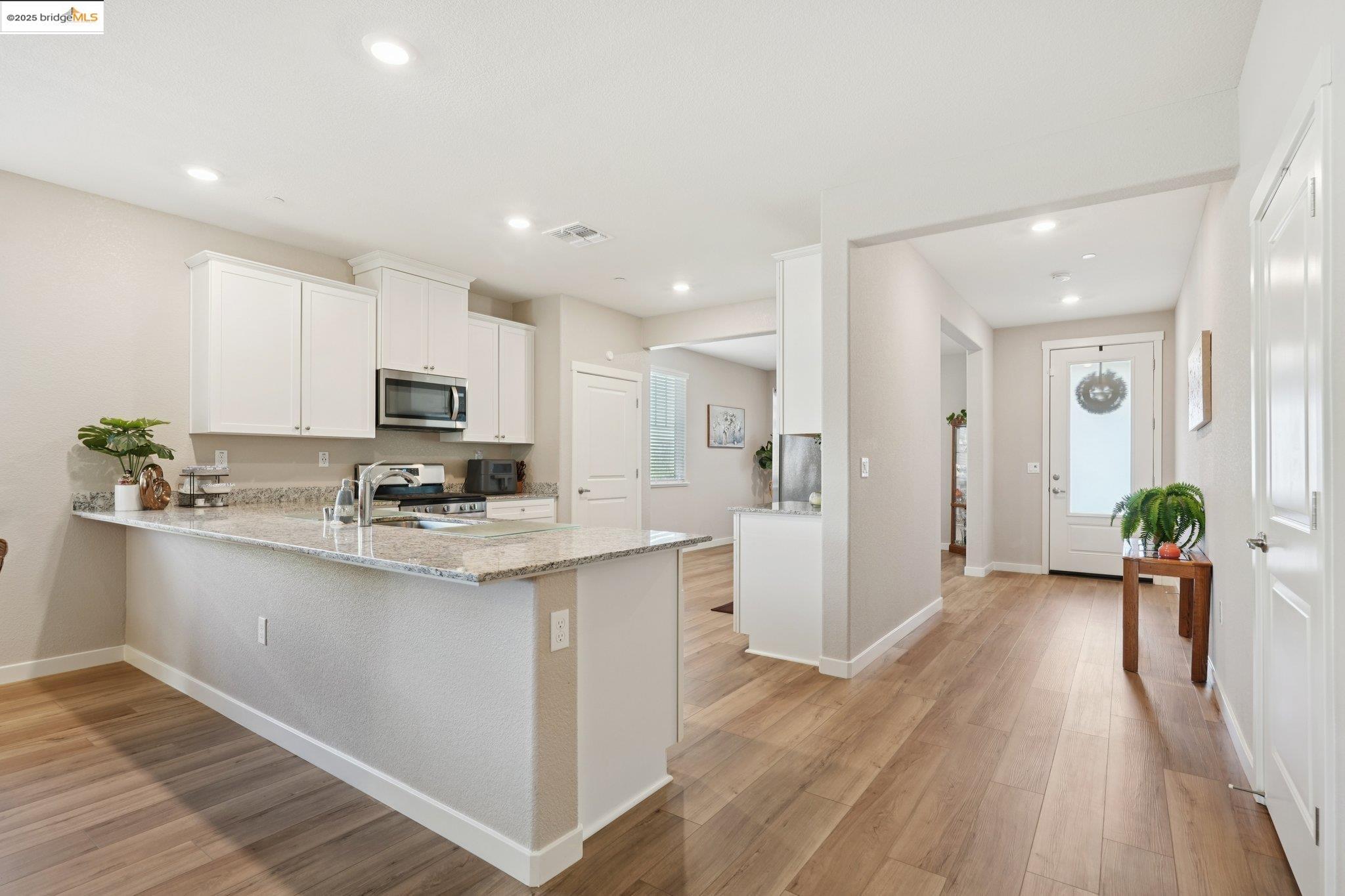 2119 Revival Lane Rio Vista, CA 94571 - Photo 9 of 44 a kitchen with stainless steel appliances granite countertop a refrigerator oven a sink dishwasher and white cabinets with wooden floor