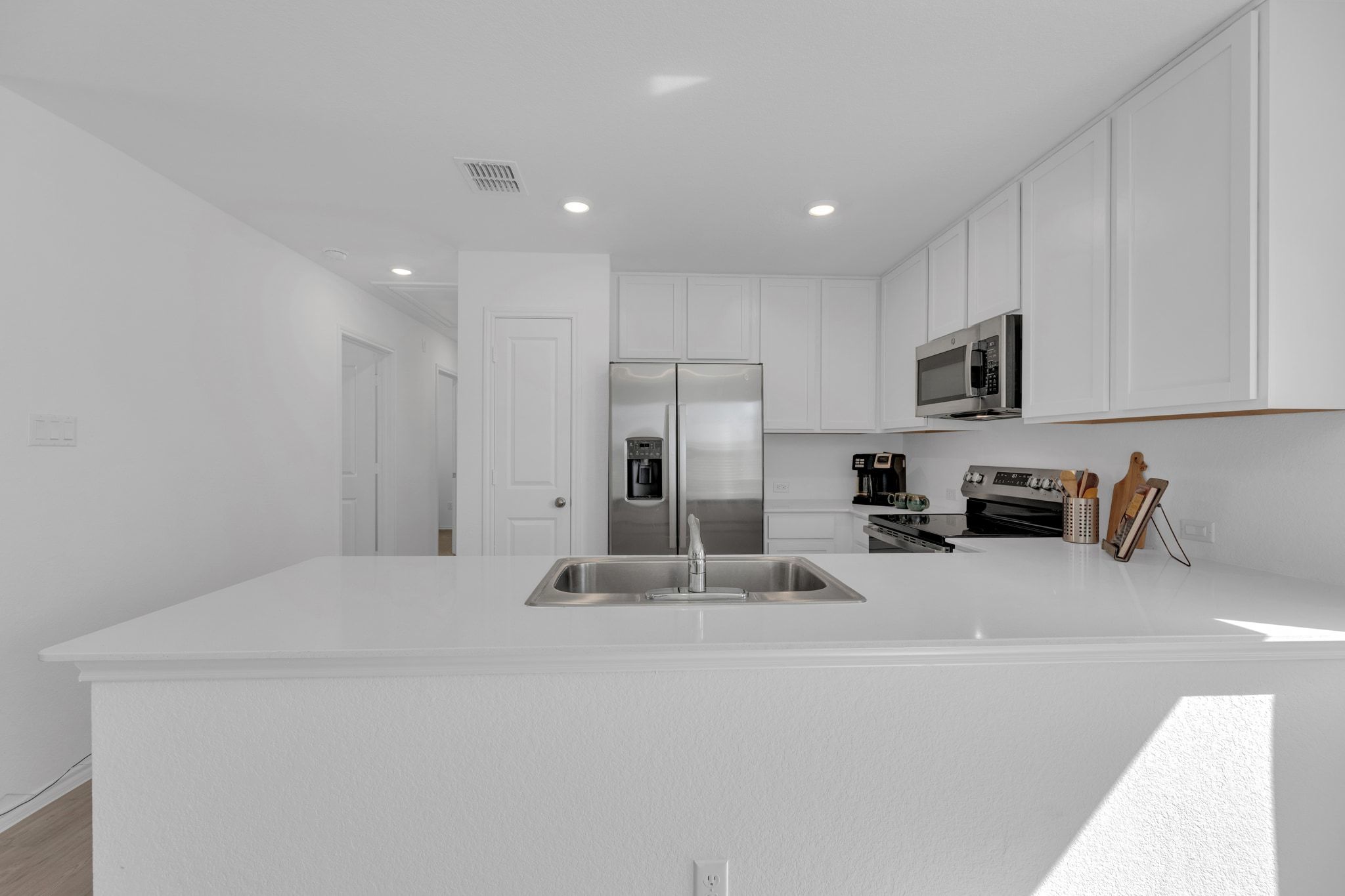 353 Marty Allen Loop Jarrell, TX 76537 - Photo 14 of 34 a kitchen with kitchen island a sink stainless steel appliances and white cabinets