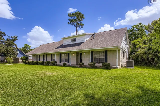 a view of a house with a big yard and potted plants