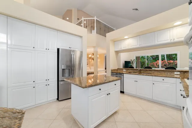a large white kitchen with a refrigerator a sink and dishwasher