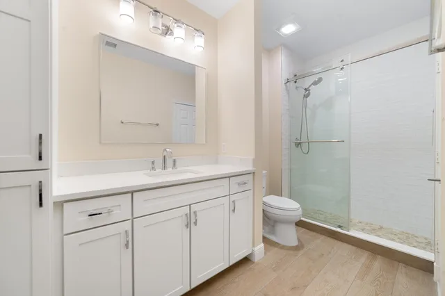 a bathroom with a sink a toilet and shower