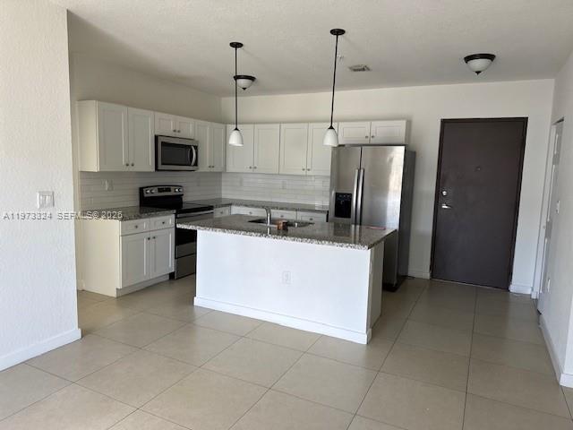 13385 Southwest 250th Street, Unit 204 Homestead, FL 33032 - Photo 2 of 8 a kitchen with stainless steel appliances granite countertop a refrigerator a stove top oven a sink and dishwasher