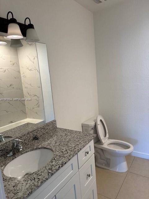 13385 Southwest 250th Street, Unit 204 Homestead, FL 33032 - Photo 8 of 8 a bathroom with a granite countertop sink toilet and mirror