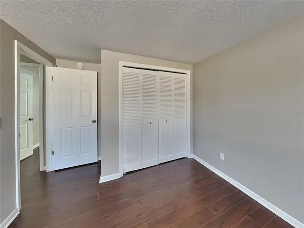 a view of an empty room with wooden floor