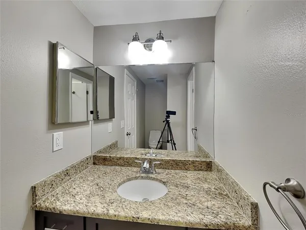 a bathroom with a granite countertop sink and a mirror