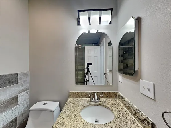 a bathroom with a granite countertop sink a mirror and vanity