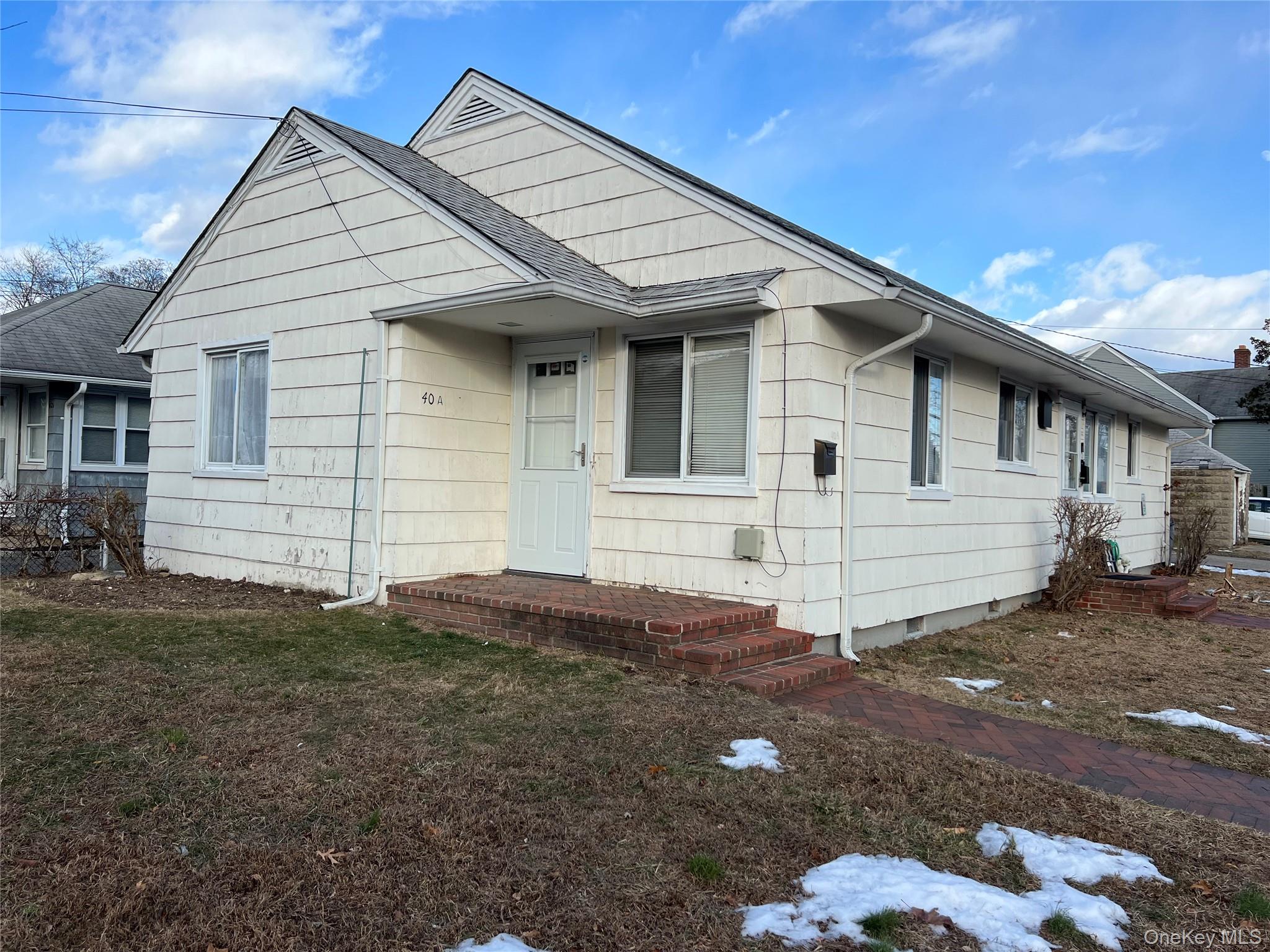 View of front of home with crawl space and a front lawn