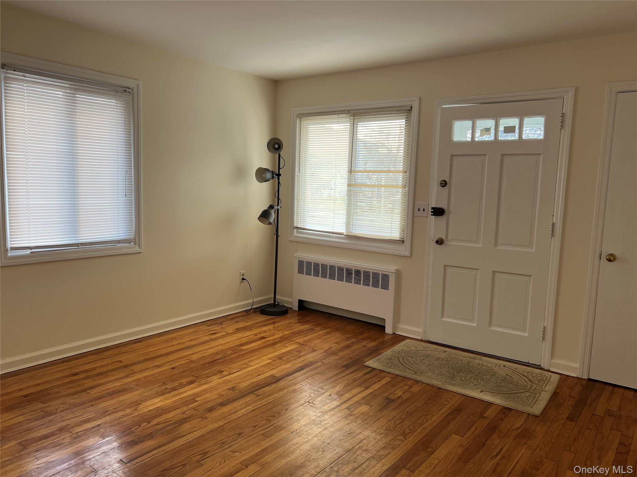 40 Firwood Road, Unit A Port Washington, NY 11050 - Photo 2 of 8 Entryway with radiator and hardwood / wood-style floors