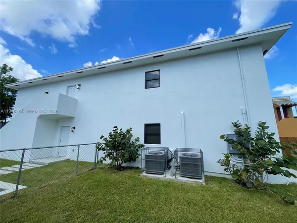 a backyard of a house with table and chairs