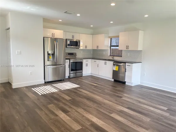 a kitchen with stainless steel appliances granite countertop a refrigerator and a stove top oven