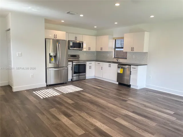 a kitchen with stainless steel appliances granite countertop a refrigerator and a stove top oven