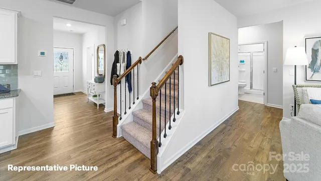 a view of a hallway with wooden floor and staircase