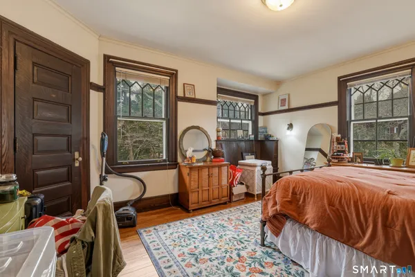 a bedroom with a bed and wooden floor