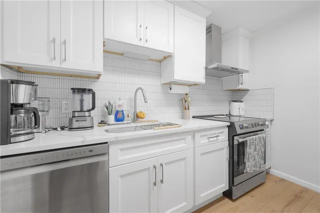 a kitchen with stainless steel appliances granite countertop white cabinets a sink and dishwasher