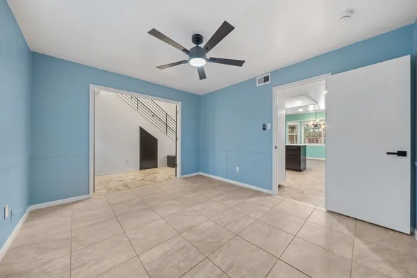 a view of a livingroom with a chandelier fan and windows