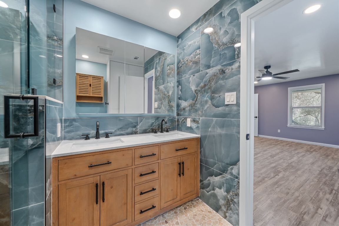 2175 Park Road New Braunfels, TX 78132 - Photo 20 of 39 Bathroom with tile walls, double vanity, ceiling fan, recessed lighting, and a stall shower