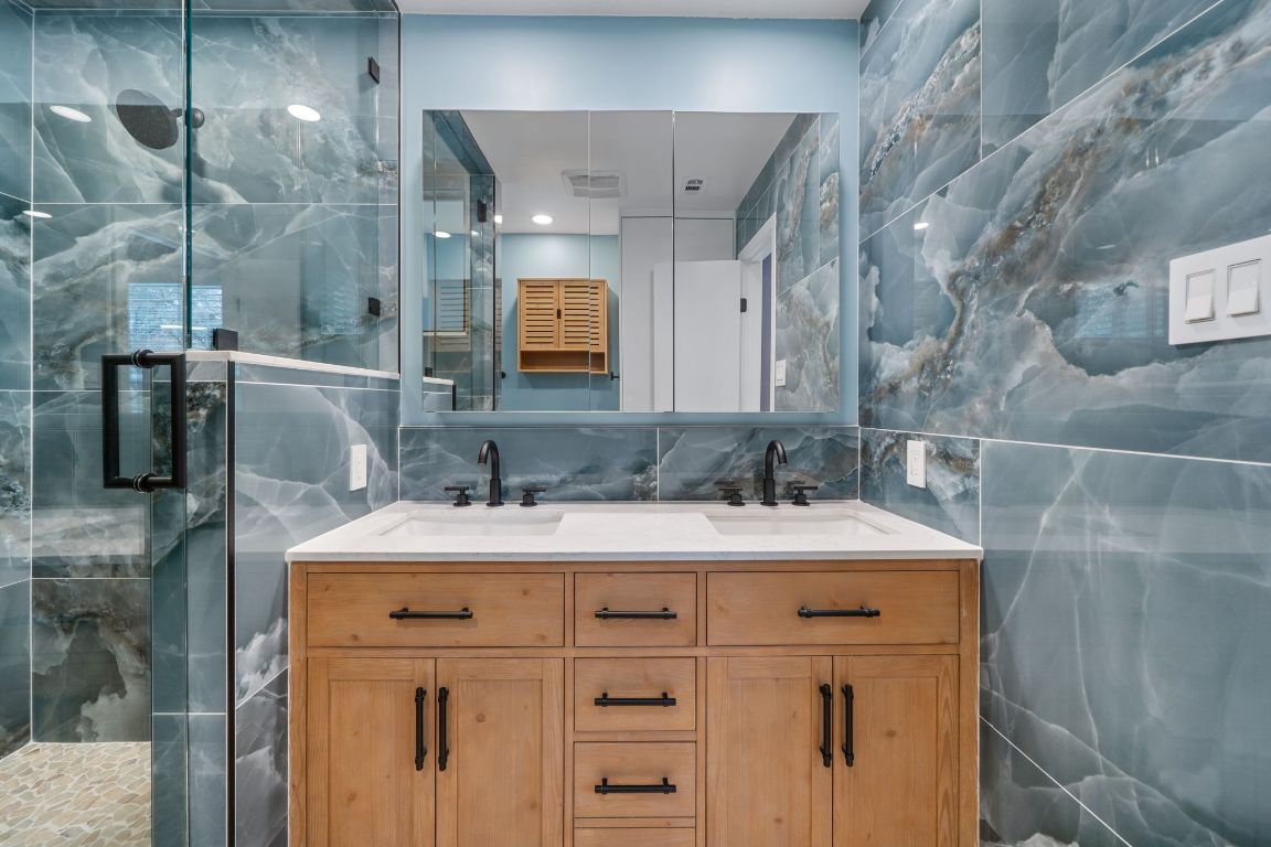 2175 Park Road New Braunfels, TX 78132 - Photo 21 of 39 Full bath featuring double vanity, tile walls, a marble finish shower, and decorative backsplash
