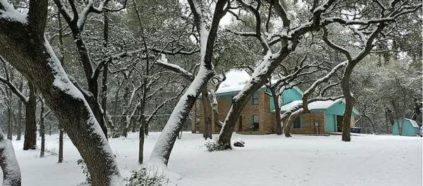 a view of snow on a sidewalk next to a building