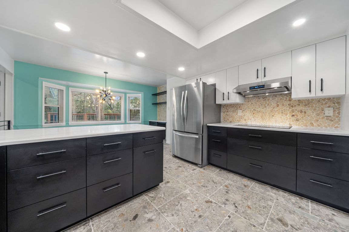 2175 Park Road New Braunfels, TX 78132 - Photo 5 of 39 Kitchen with dark cabinets, tasteful backsplash, modern cabinets, freestanding refrigerator, and white cabinets