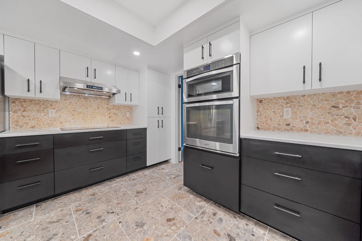 2175 Park Road New Braunfels, TX 78132 - Photo 6 of 39 Kitchen featuring white cabinetry, backsplash, double oven, modern cabinets, and under cabinet range hood