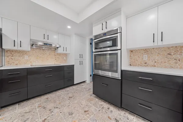 a kitchen with stainless steel appliances granite countertop a refrigerator and a sink