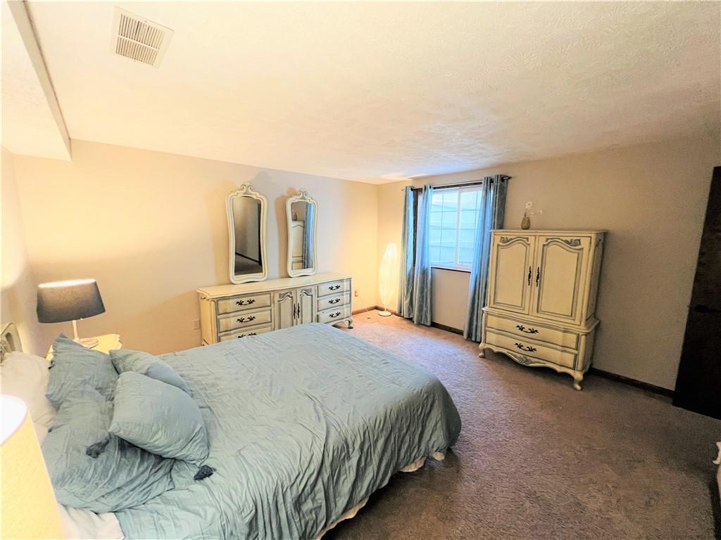 789 Cleland Mill Road New Castle, PA 16102 - Photo 22 of 25 a spacious bedroom with a bed a dresser and mirror