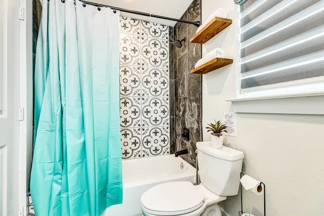 a white toilet sitting next to a shower curtain