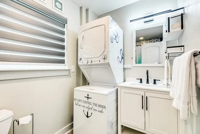 a utility room with a washer dryer and white cabinets