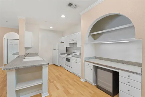 a kitchen with granite countertop white cabinets and white appliances