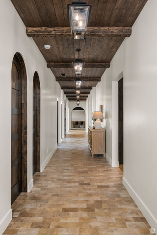 4871 South Homestead Way Washington, UT 84780 - Photo 66 of 151 Hall with arched walkways, a wooden ceiling with exposed beams, and light wood-style floors