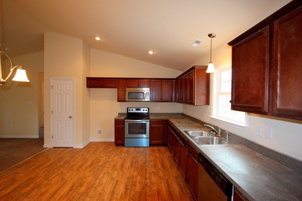 13 Winding Ridge Way Bumpass, VA 23024 - Photo 10 of 17 a kitchen with stainless steel appliances granite countertop a stove a sink dishwasher and a refrigerator with wooden floor