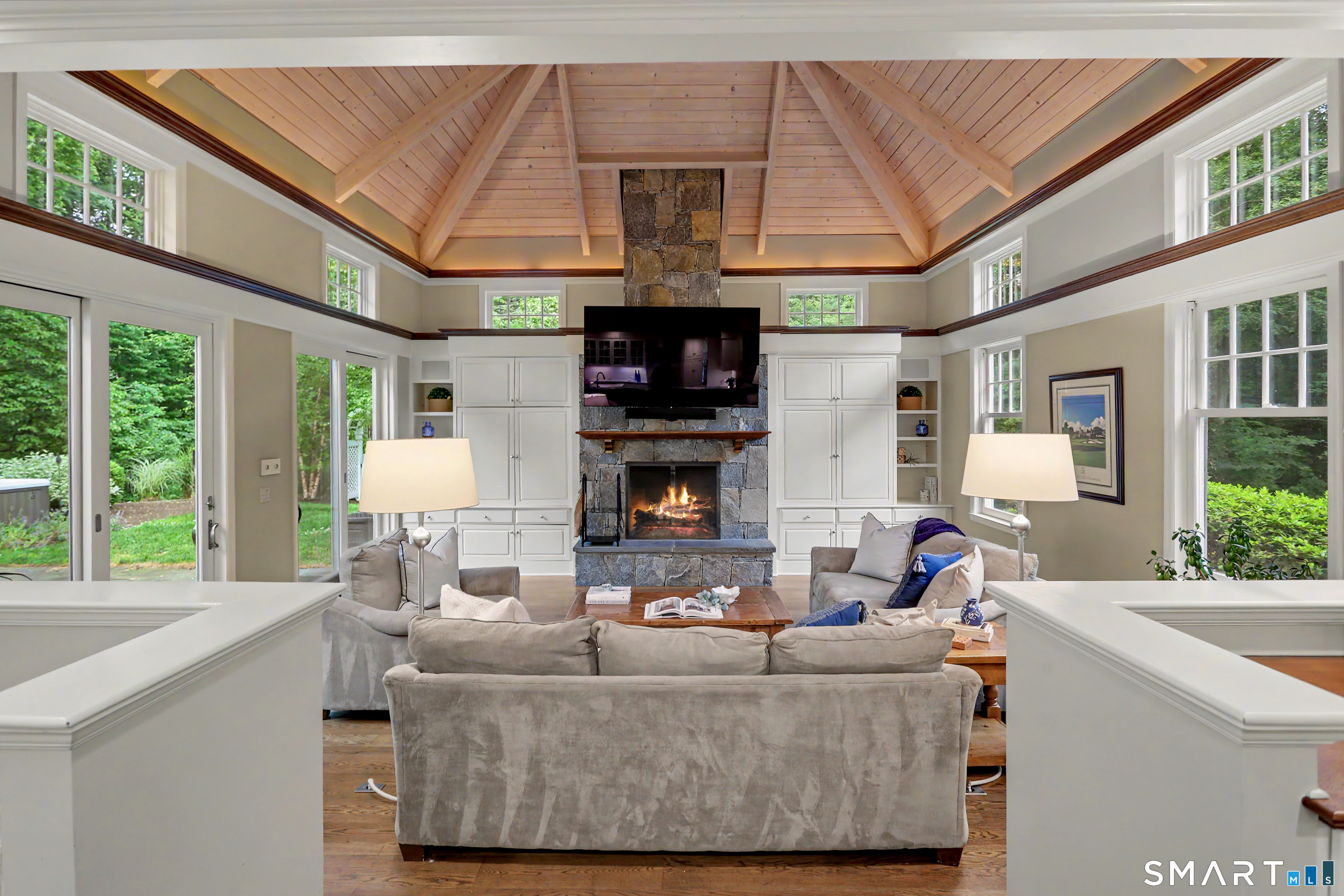 108 Logan Road New Canaan, CT 06840 - Photo 11 of 40 a living room with furniture a fireplace a large window and a chandelier