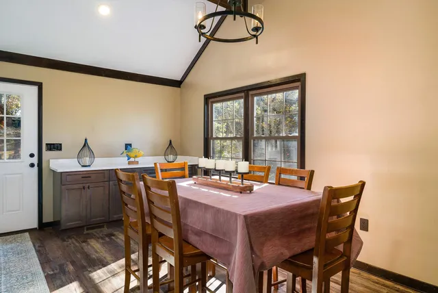 a view of a livingroom with a fireplace a ceiling fan and wooden floor