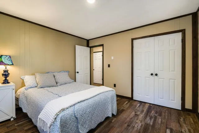 a bedroom with a bed and wooden floor