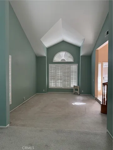 an empty room with windows and fireplace