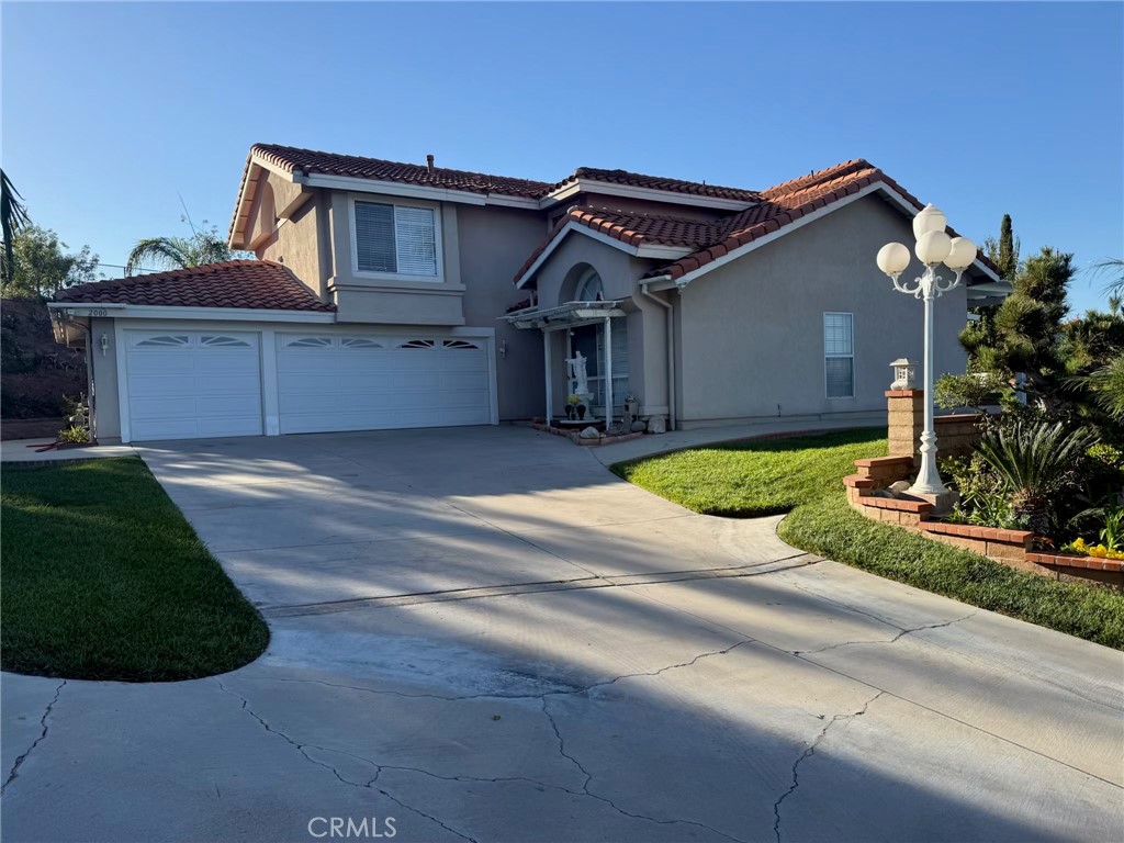 2000 Citrus Wood Lane Riverside, CA 92503 - Photo 2 of 51 a front view of a house with a yard and garage