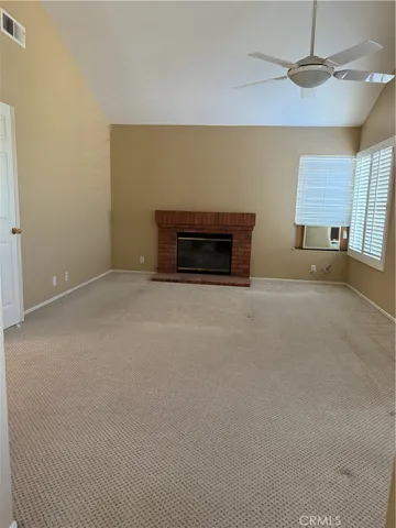 an empty room with windows and fireplace