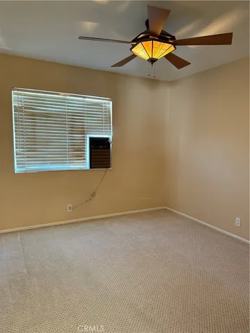an empty room with a window and potted plants