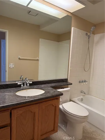 a bathroom with a granite countertop sink toilet mirror and shower