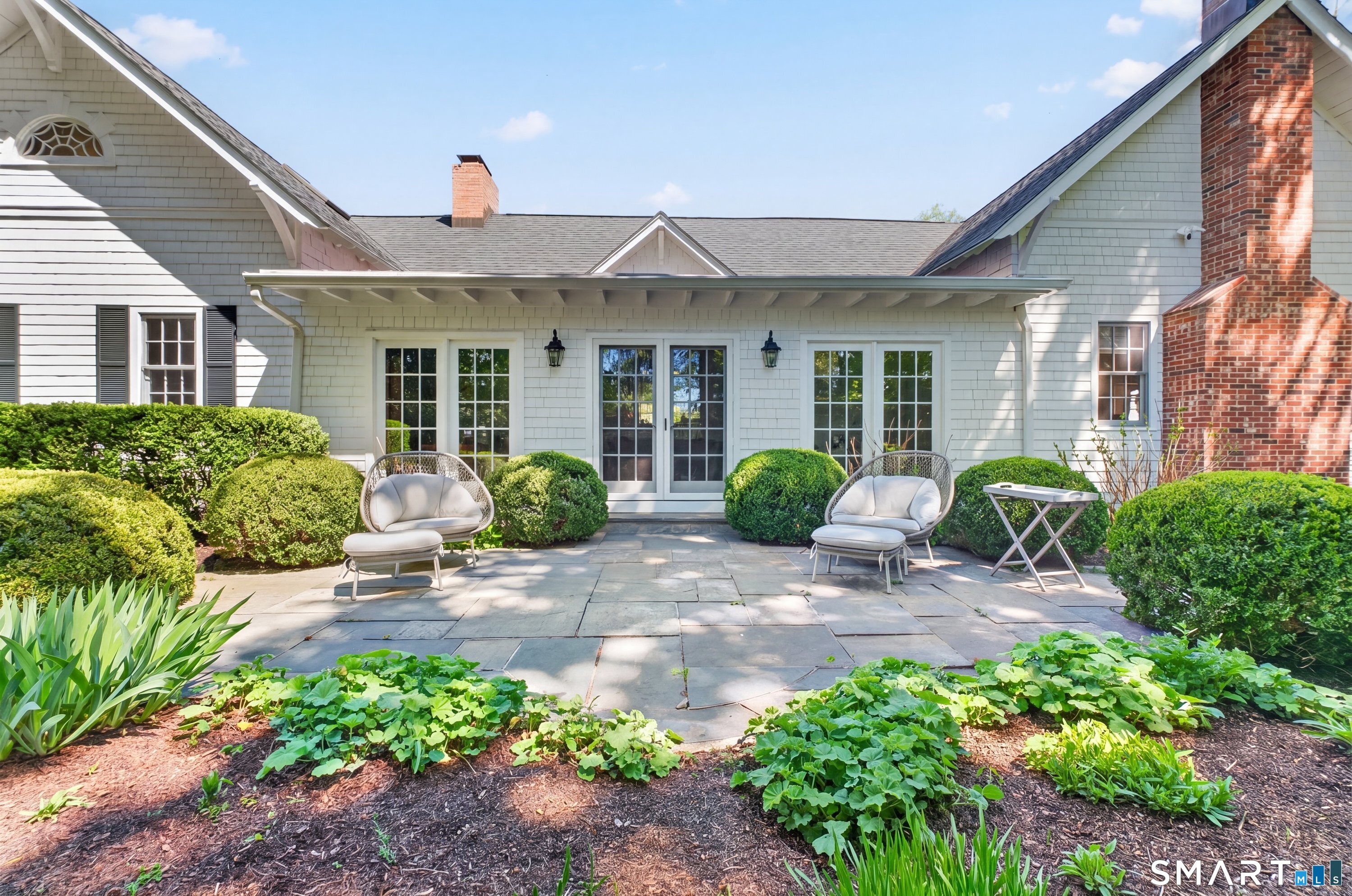 41 Peaceable Street Ridgefield, CT 06877 - Photo 34 of 40 a front view of a house with garden and plants