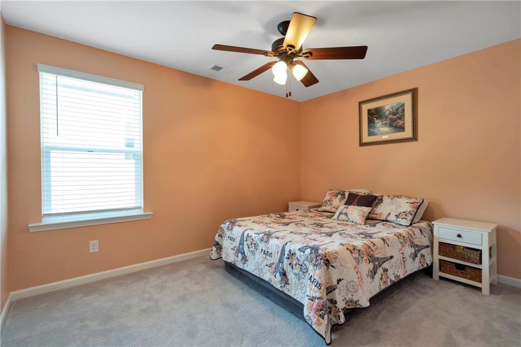 660 Groover Street Ball Ground, GA 30107 - Photo 32 of 53 a bedroom with a bed and a chandelier
