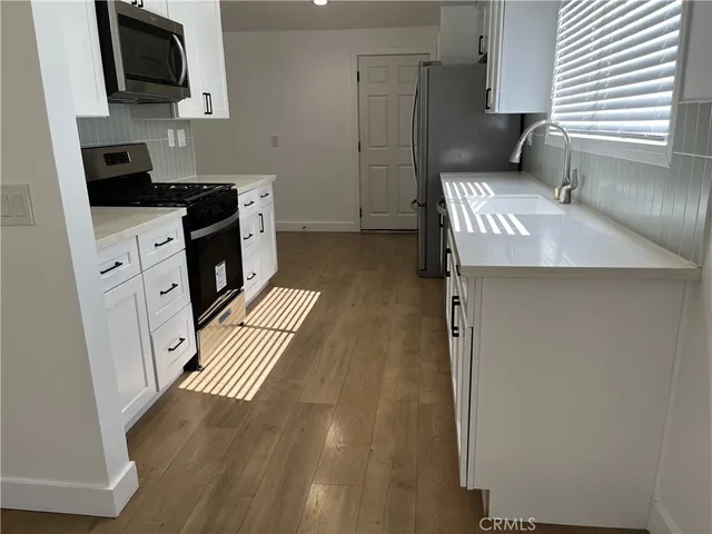 a kitchen with granite countertop a sink stove and refrigerator