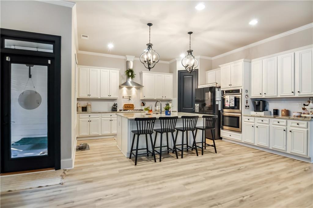 601 Legacy Run Ball Ground, GA 30107 - Photo 11 of 58 a open kitchen with stainless steel appliances granite countertop a stove top oven a refrigerator a sink and a dining table with wooden floor