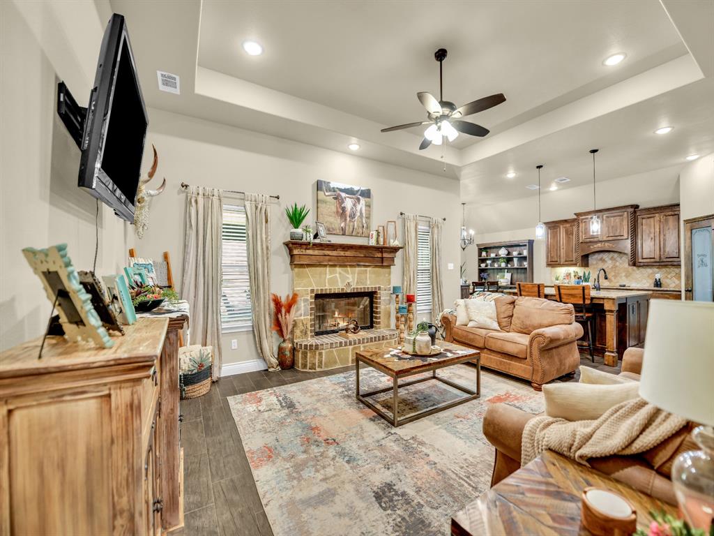 156 Cottongame Road Weatherford, TX 76088 - Photo 6 of 35 a living room with furniture a fireplace and a flat screen tv